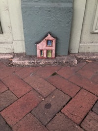 a small house on a brick sidewalk