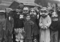 a group of people wearing masks in front of a building