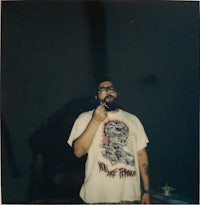 a man in a t - shirt holding a cell phone