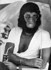 a monkey wearing sunglasses and holding an umbrella