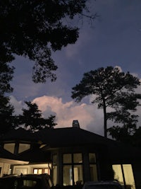 a house with trees and clouds in the sky