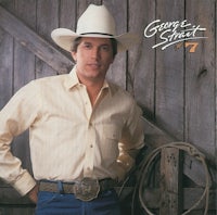 a man in a cowboy hat is leaning against a wooden fence