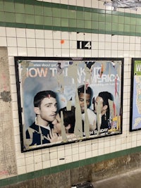 a subway station with posters on the wall