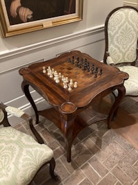 a chess table in a room with chairs