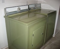 a green washer and dryer in a small room